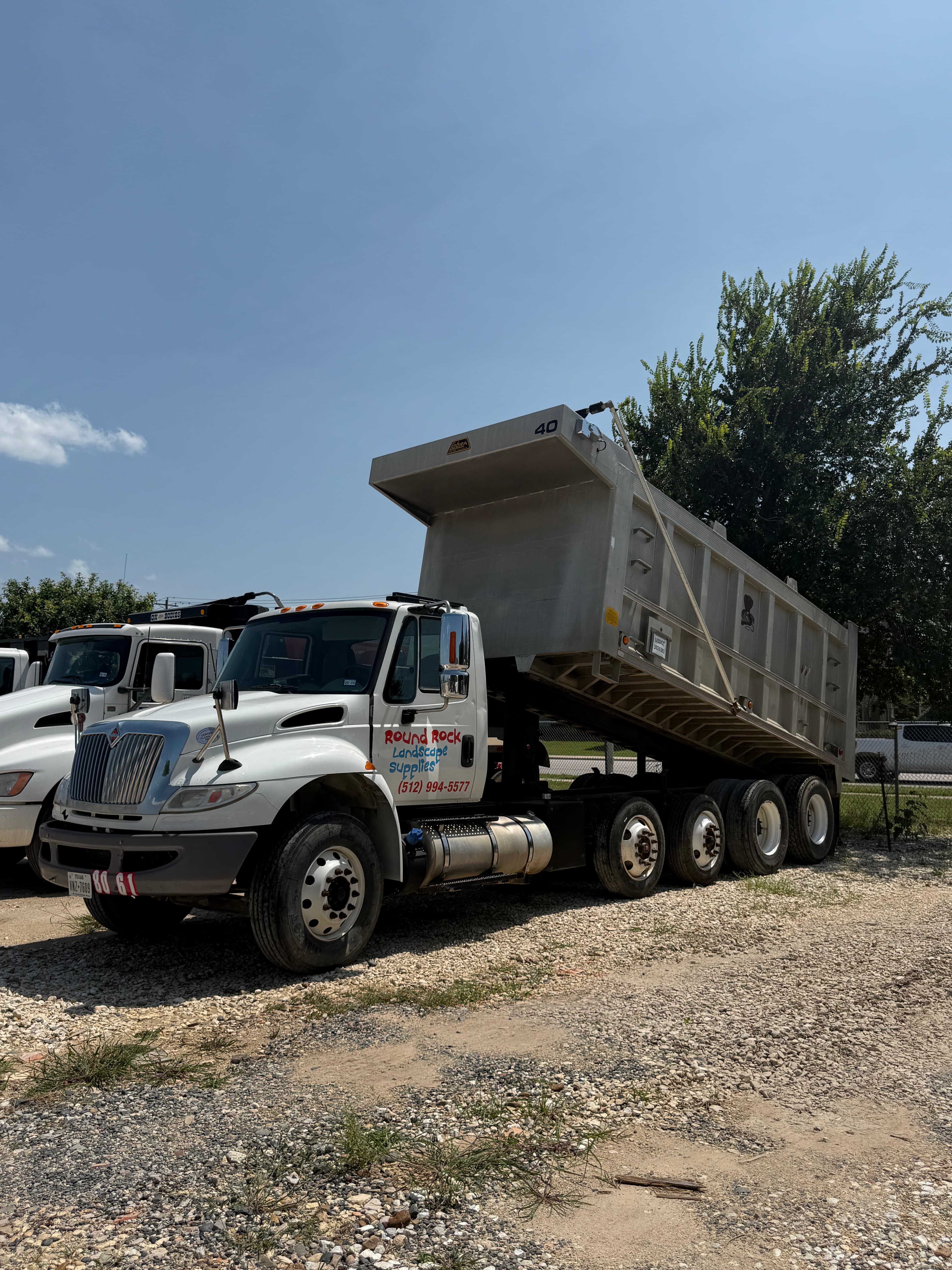 A Round Rock Landscape Supplies branded dump truck ready to deliver bulk materials across Central Texas